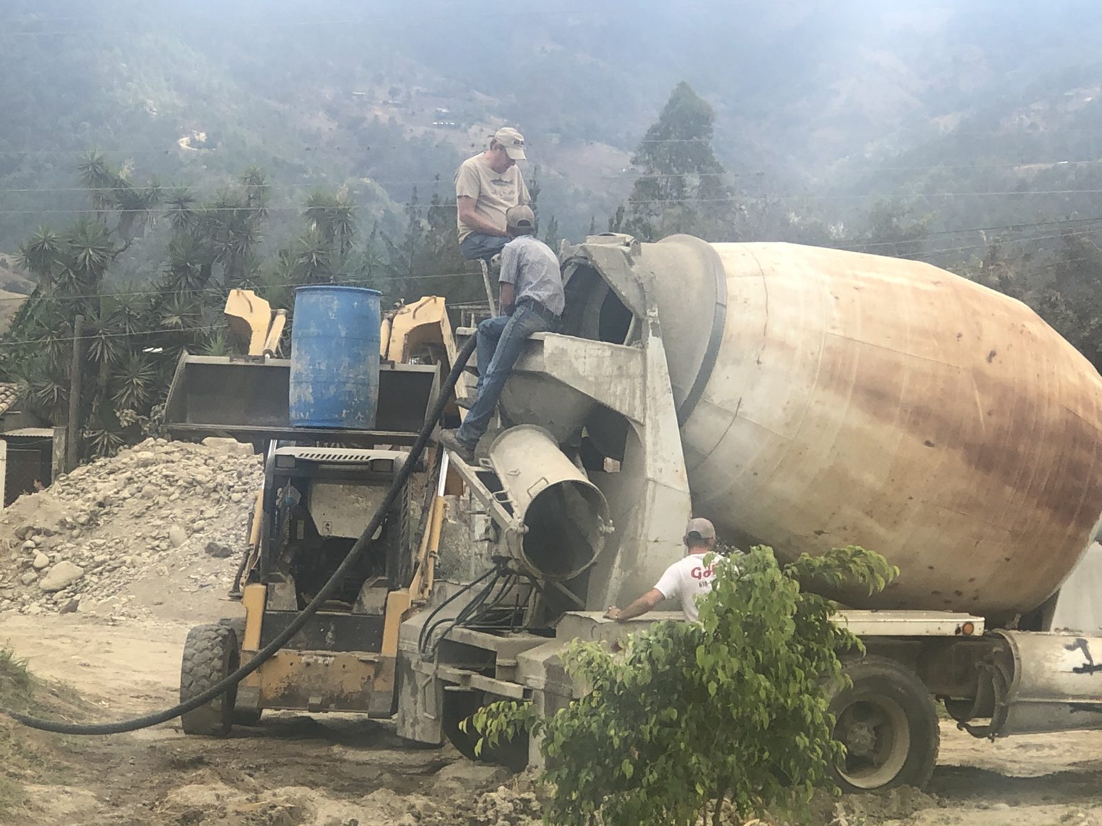 Volunteers on a concrete mixer during construction of the Adonai hospital in the Guatemalan highlands