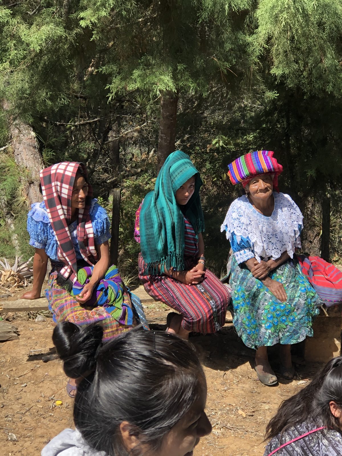 Three Maya women in traditional Guatemalan dress at an Adonai community gathering near Canillá