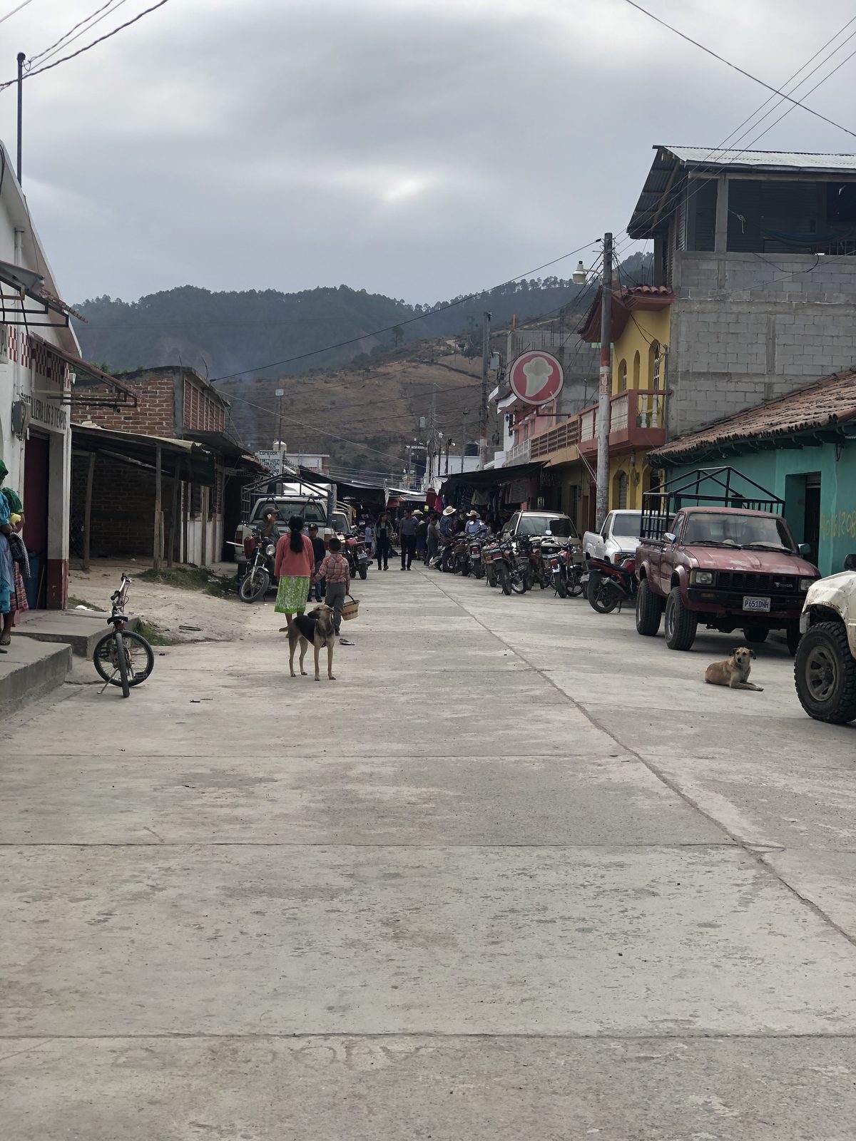 A street in the highland town of Canillá, Guatemala, with shops and motorcycles